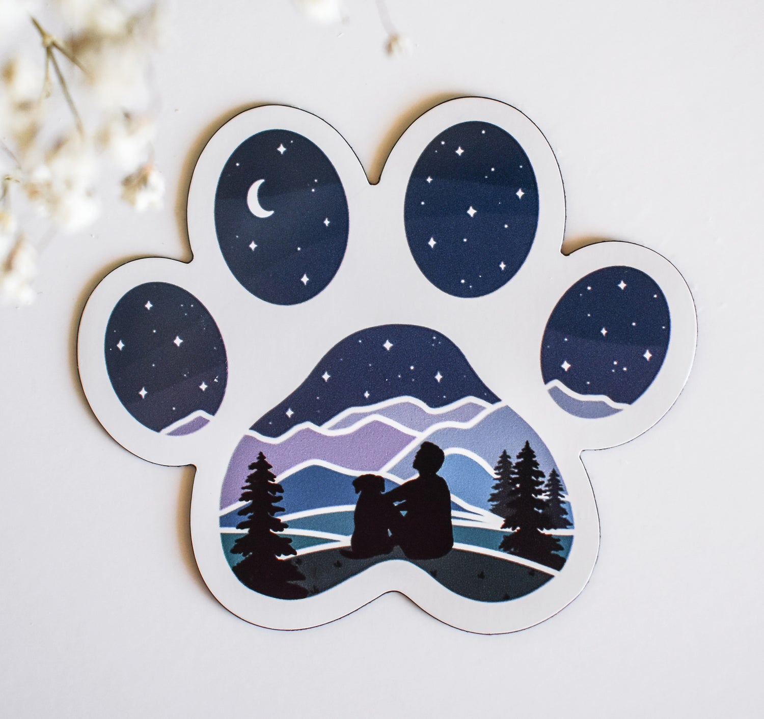 Man and his dog stargazing over the mountains refrigerator magnet in the shape of a dog paw print