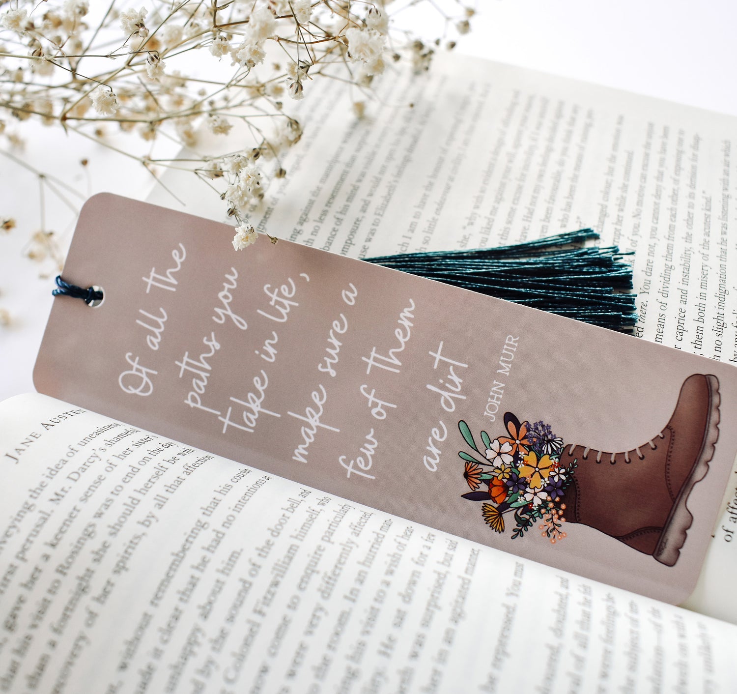 Bookmark with the John Muir quote "Of all the paths you take in life, make sure a few of them are dirt" and a hiking boot with flowers design