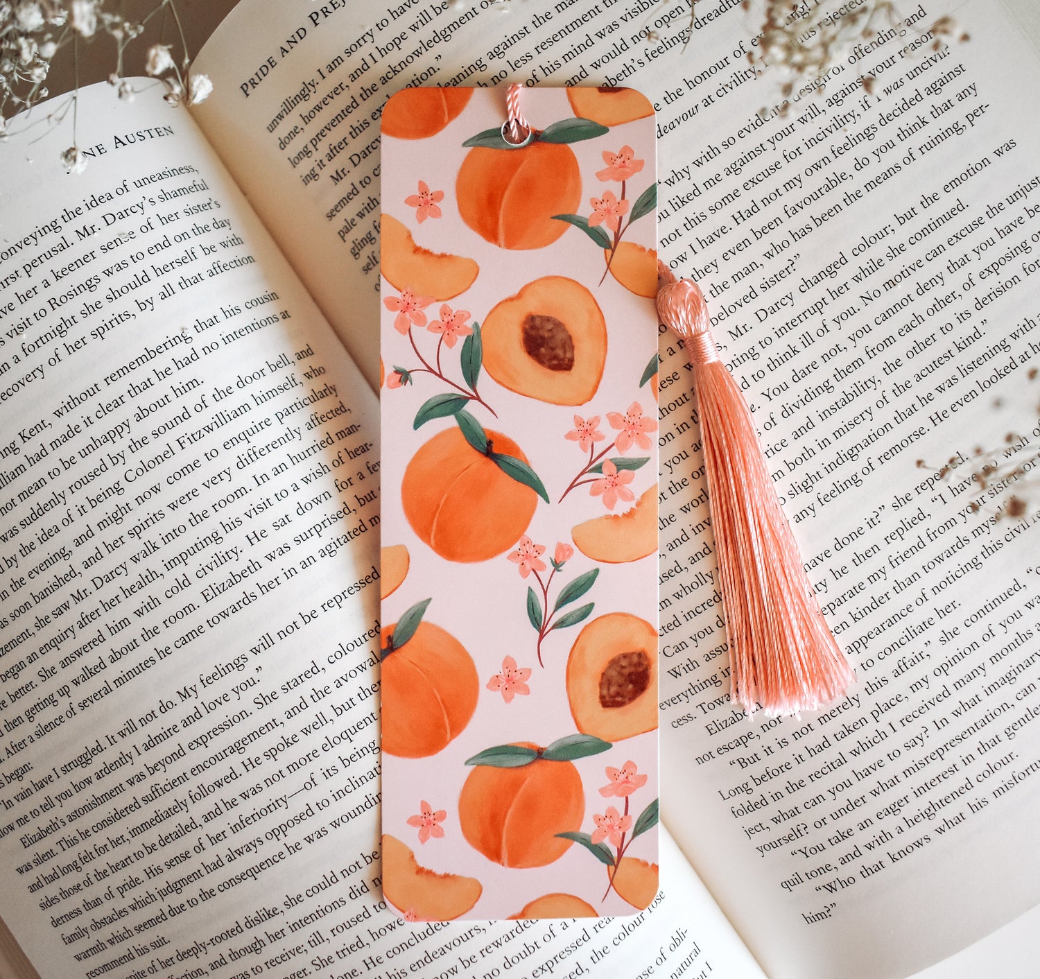 Bookmark with peach artwork design printed on both sides and a pink tassel