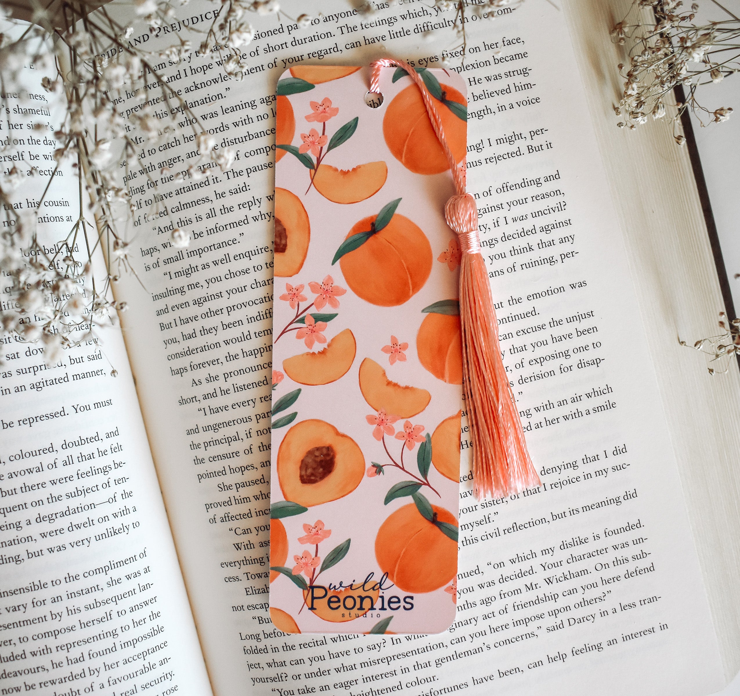 Bookmark with peach artwork design printed on both sides and a pink tassel