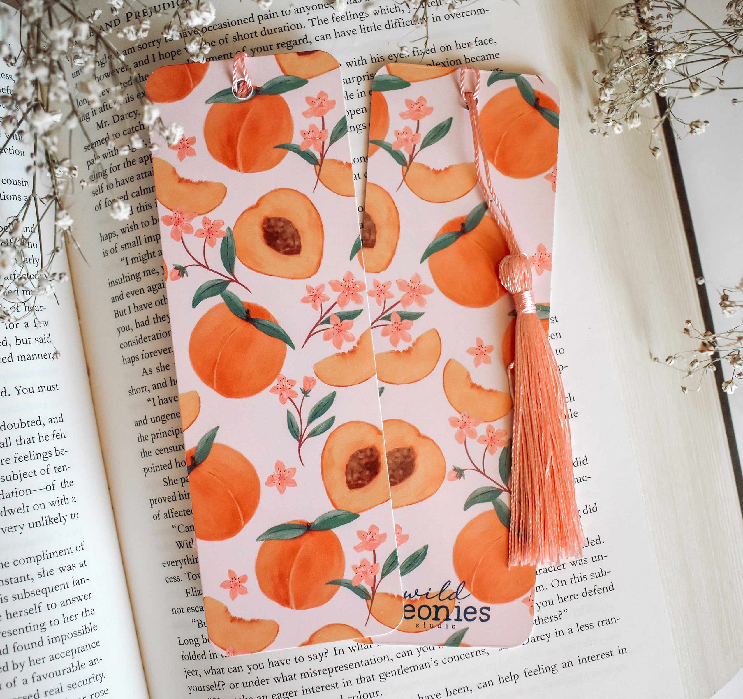 Bookmark with peach artwork design printed on both sides and a pink tassel