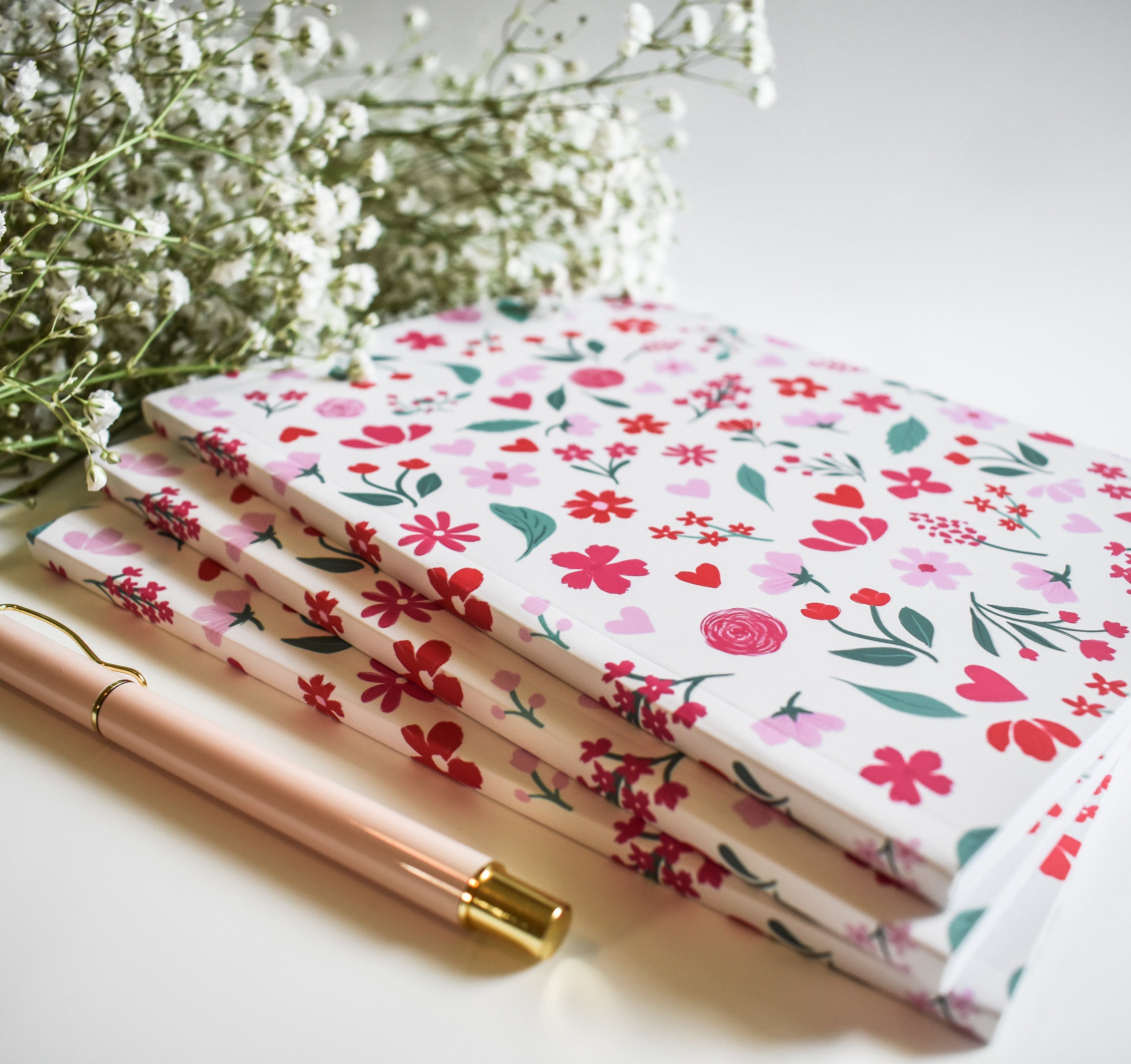 Notebook with pink and red flowers on a light pink background