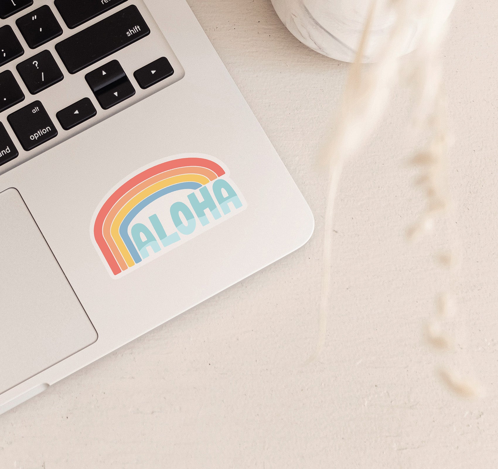 Clear Hawaiian aloha laptop sticker with a rainbow