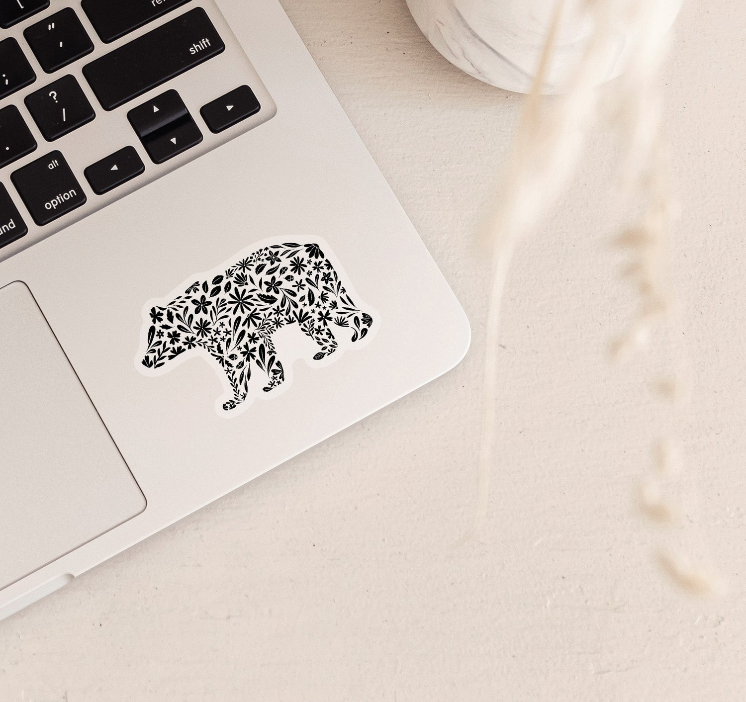 Decorative bear clear vinyl sticker with black floral patterns on a laptop