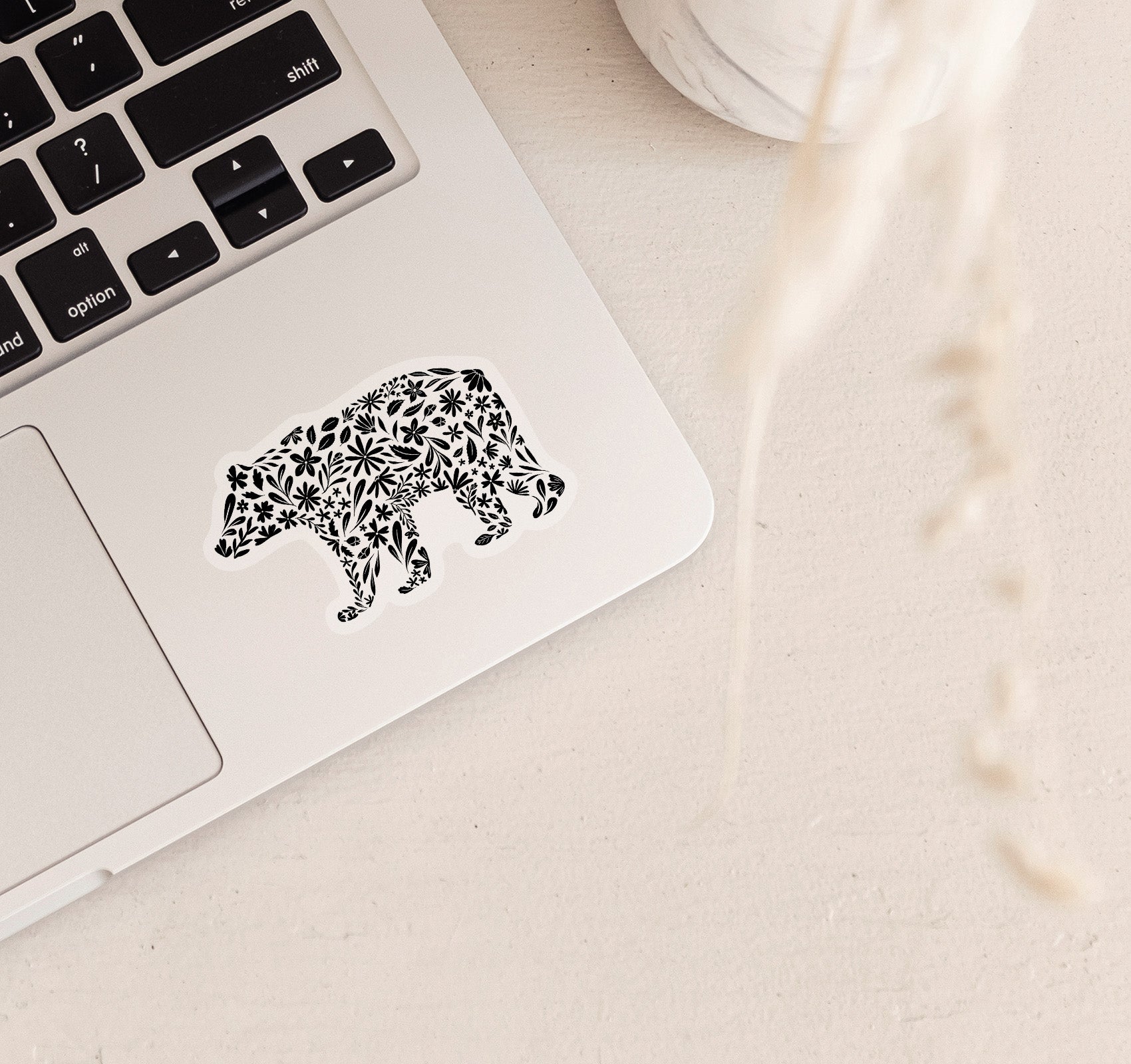 Decorative bear clear vinyl sticker with black floral patterns on a laptop