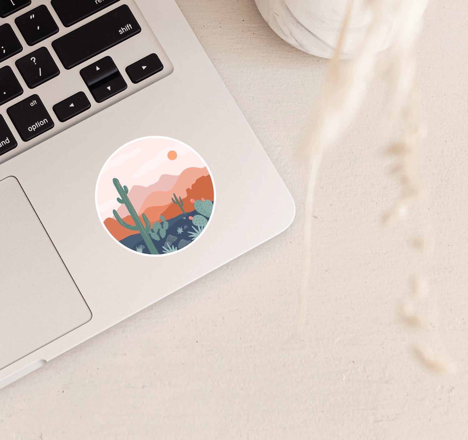 Round boho sticker of desert scenery with a saguaro cactus and the mountains at sunset