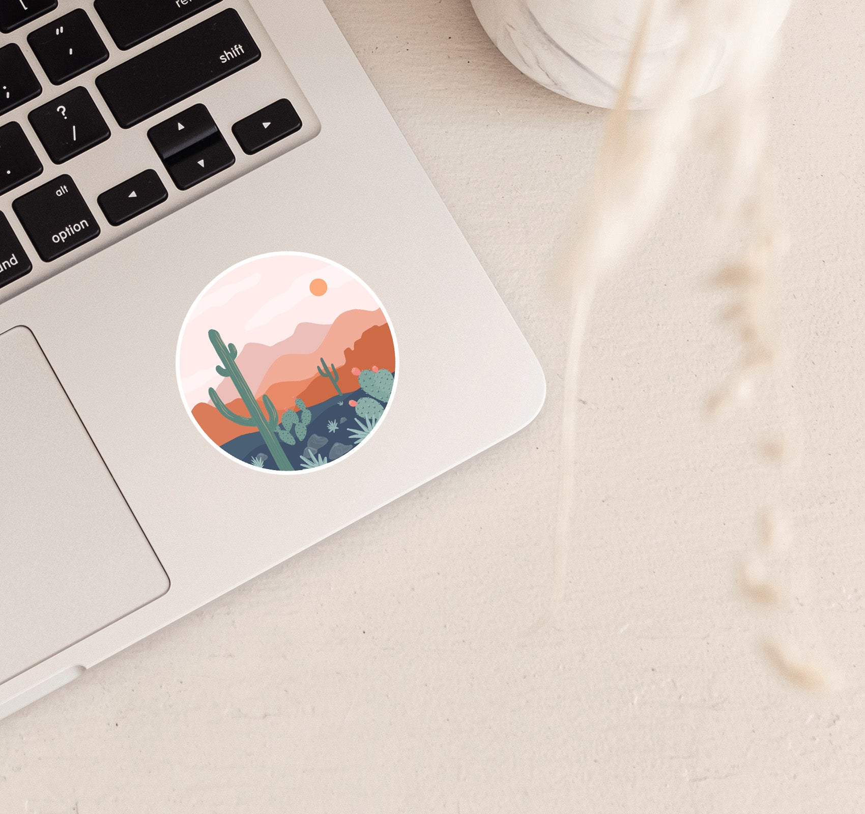 Round boho sticker of desert scenery with a saguaro cactus and the mountains at sunset