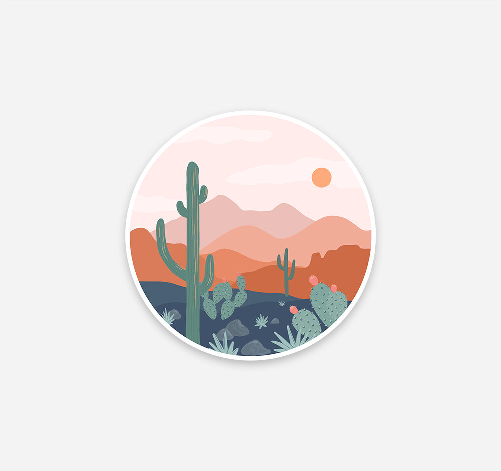 Round boho sticker of desert scenery with a saguaro cactus and the mountains at sunset