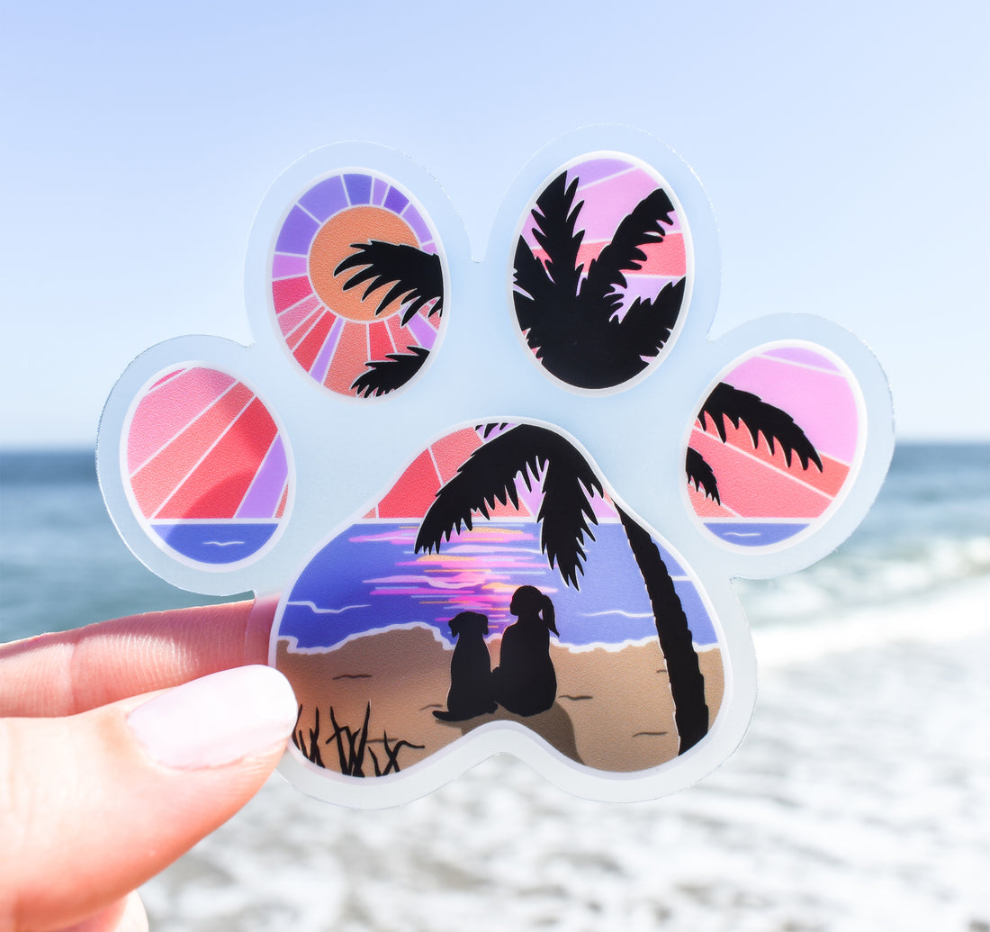 Dog paw print sticker of a girl and her dog watching the sunset at the beach