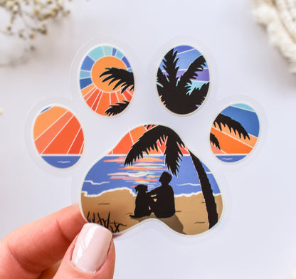 Dog paw print sticker of a man and his dog watching the sunset at the beach