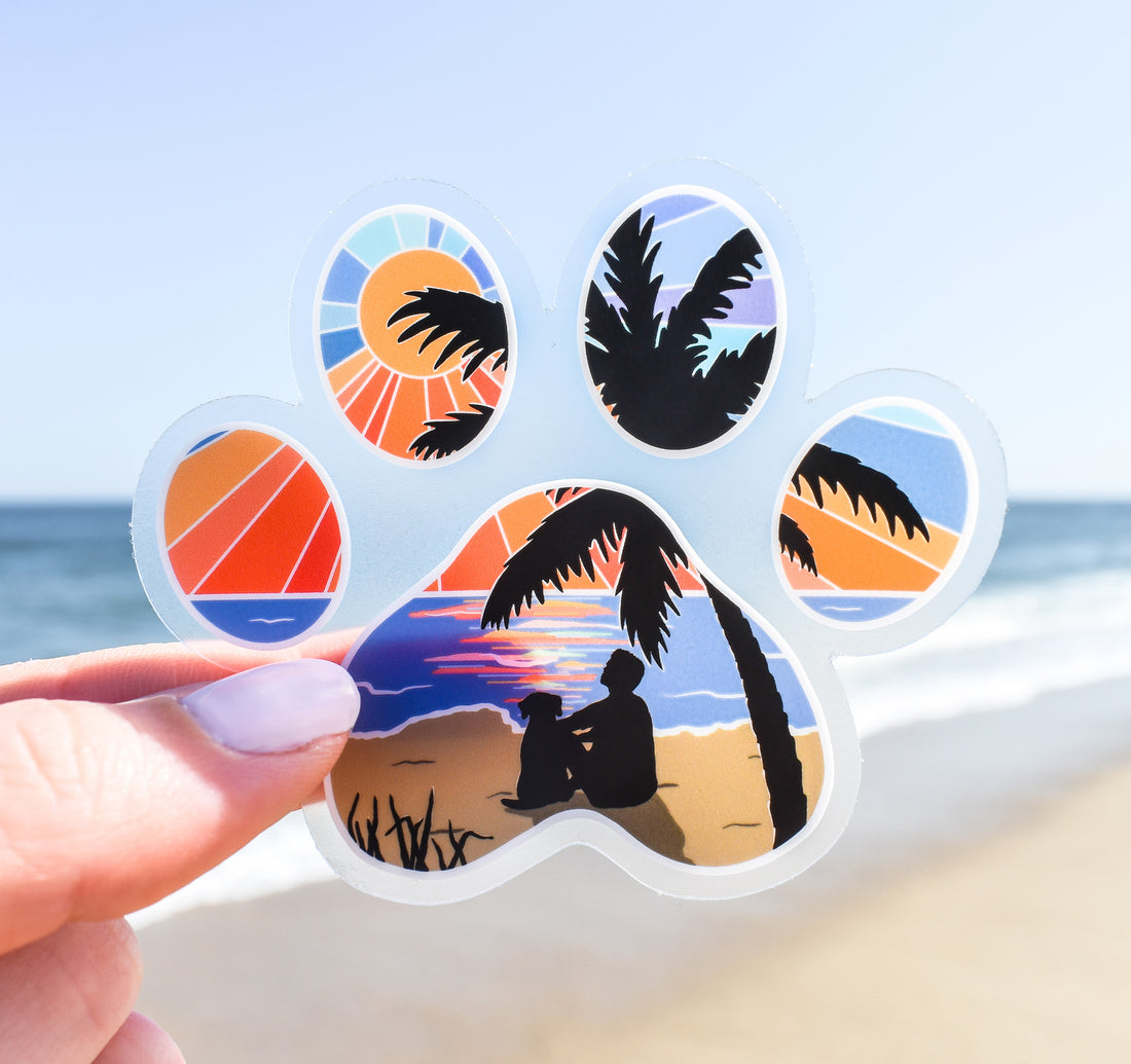 Dog paw print sticker of a man and his dog watching the sunset at the beach