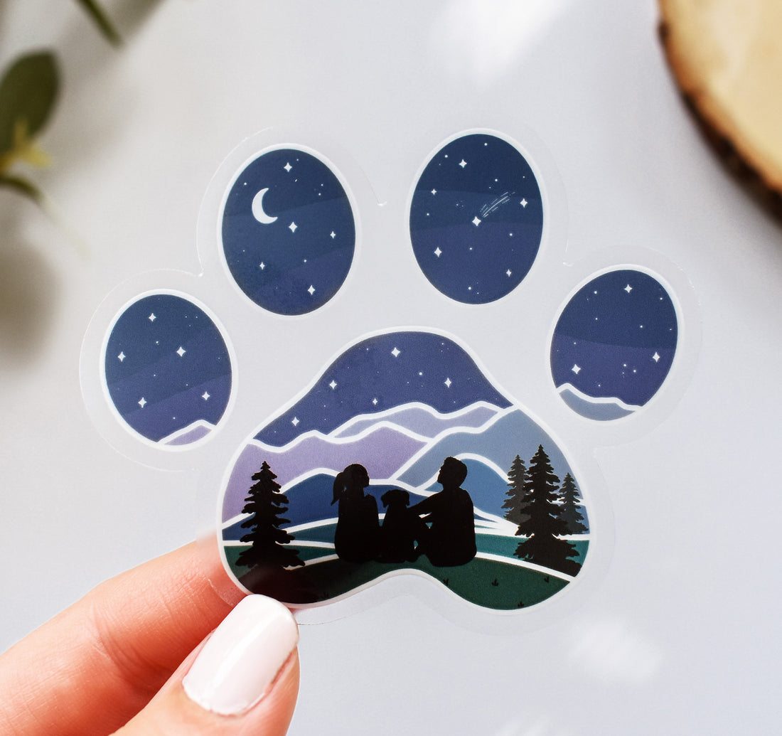 Dog paw print sticker with a couple and their dog looking at the stars