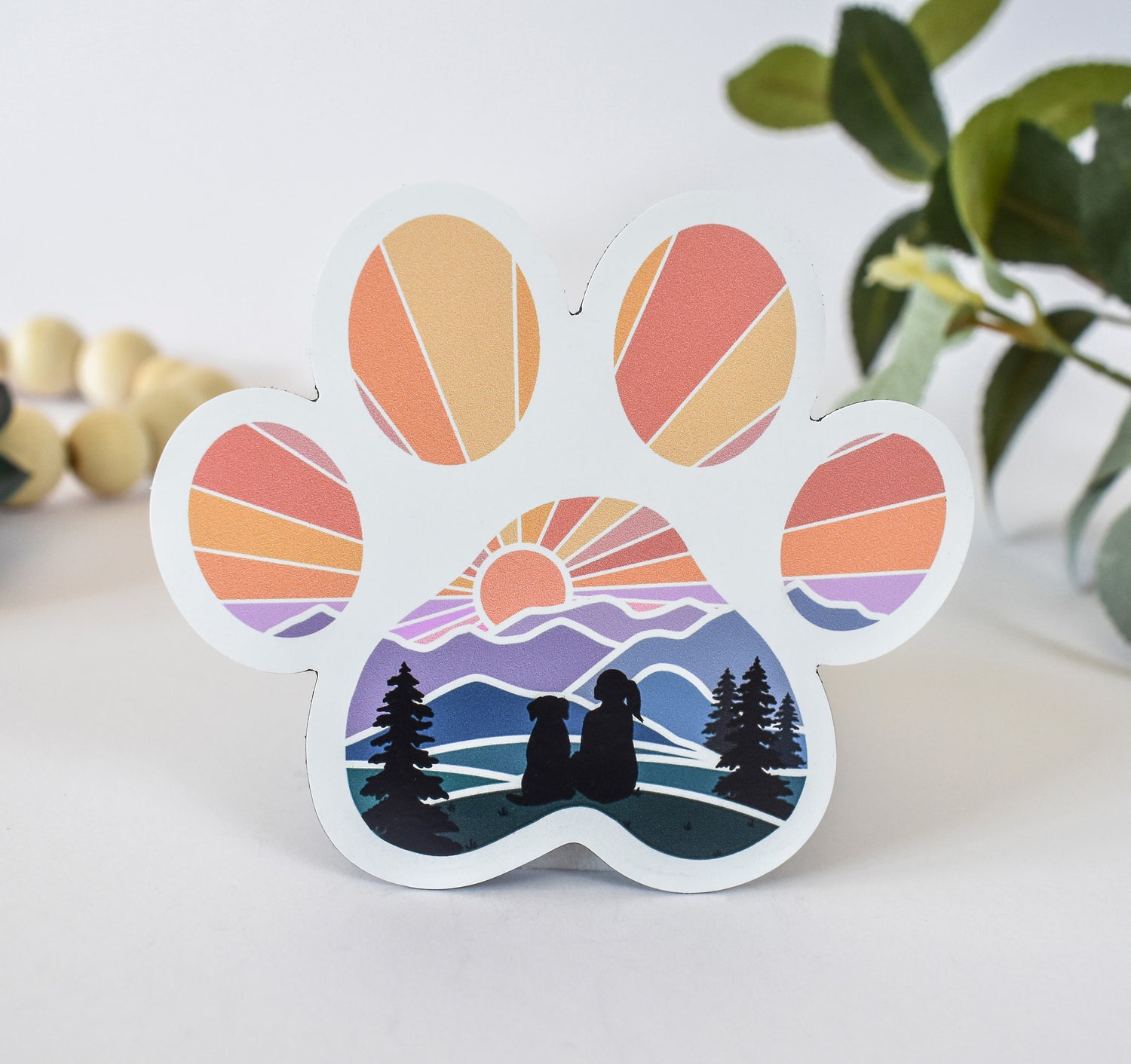 Magnet of a dog paw print with a girl and her dog watching the sunset over the mountains