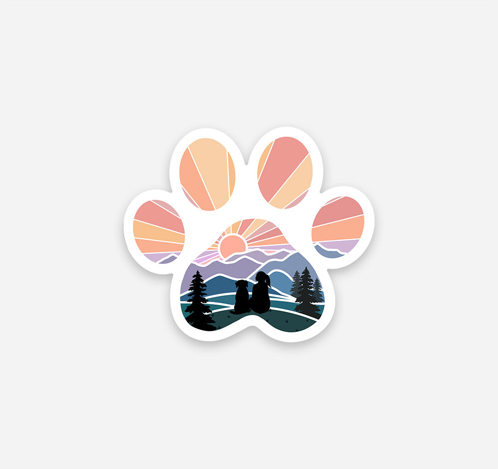 Magnet of a dog paw print with a girl and her dog watching the sunset over the mountains