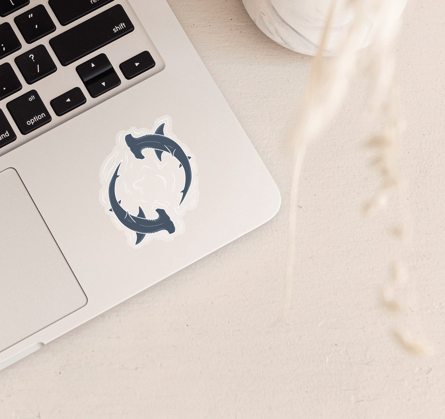 Clear vinyl laptop sticker of two hammerhead sharks circling through water