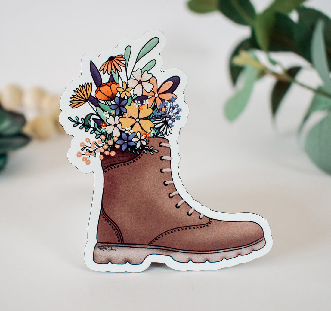 A magnet of a hiking boot overflowing with wildflowers
