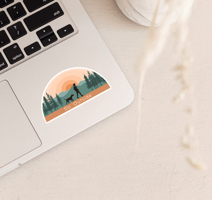 Hiking laptop sticker of a girl and dog at sunset in the mountains