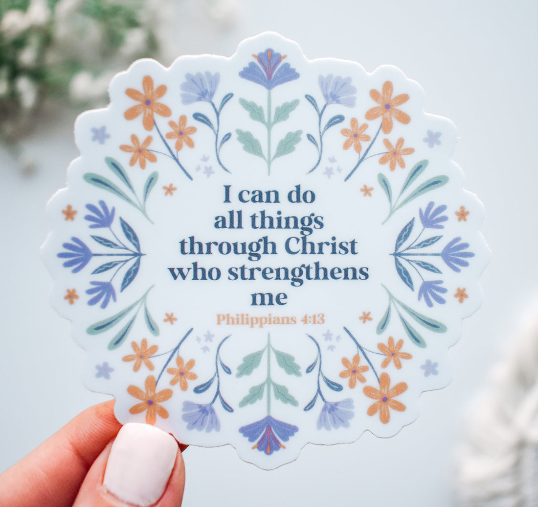Decorative Christian faith sticker with the Bible verse "I can do all things through Christ who strengthens me, Philippians 4:13" surrounded by hand-drawn purple and orange flowers.