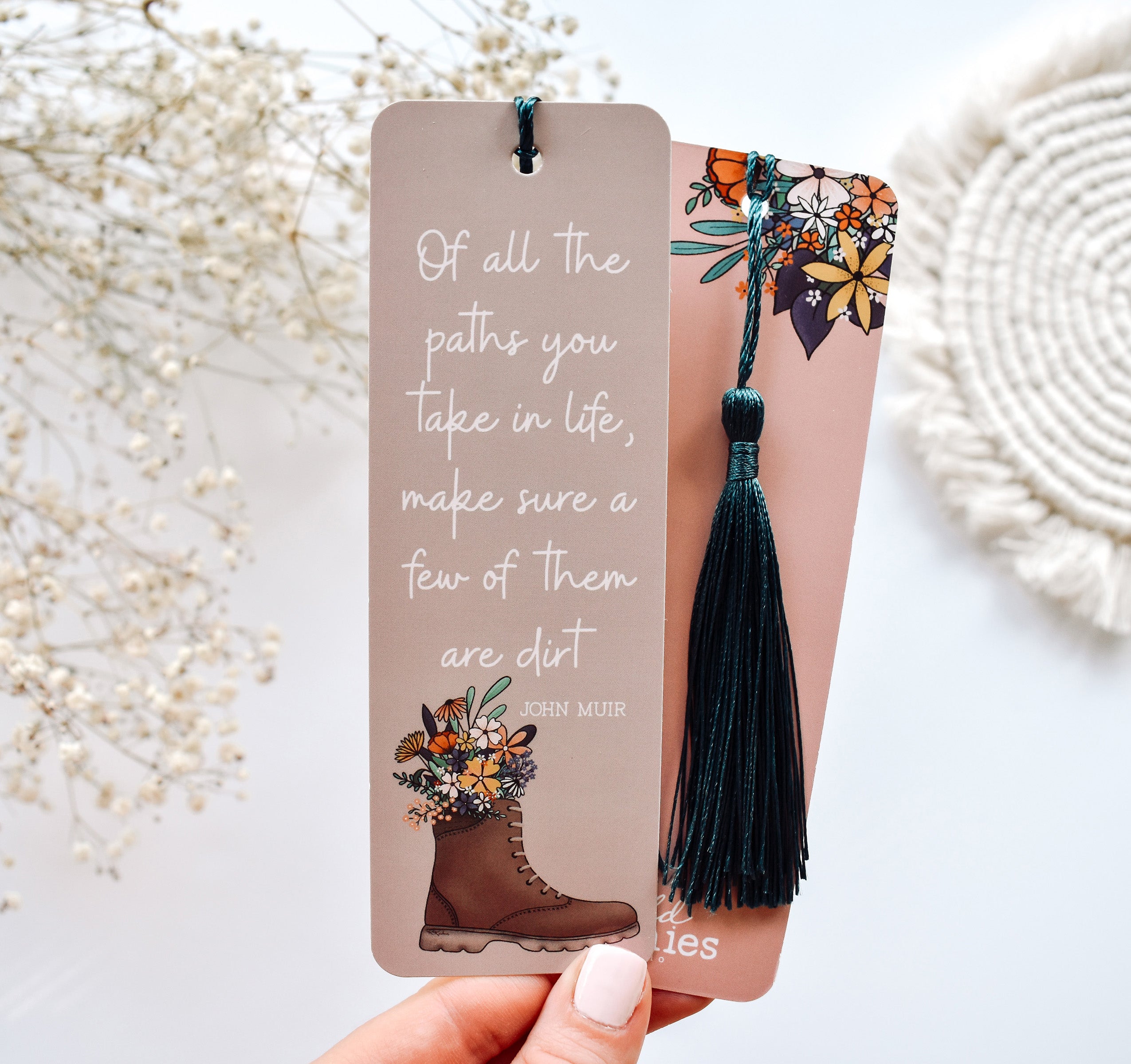 Bookmark with the John Muir quote &quot;Of all the paths you take in life, make sure a few of them are dirt&quot; and a hiking boot with flowers design