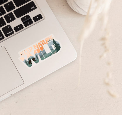 Keep Nature Wild laptop sticker of a bear by the forest and mountains at sunset