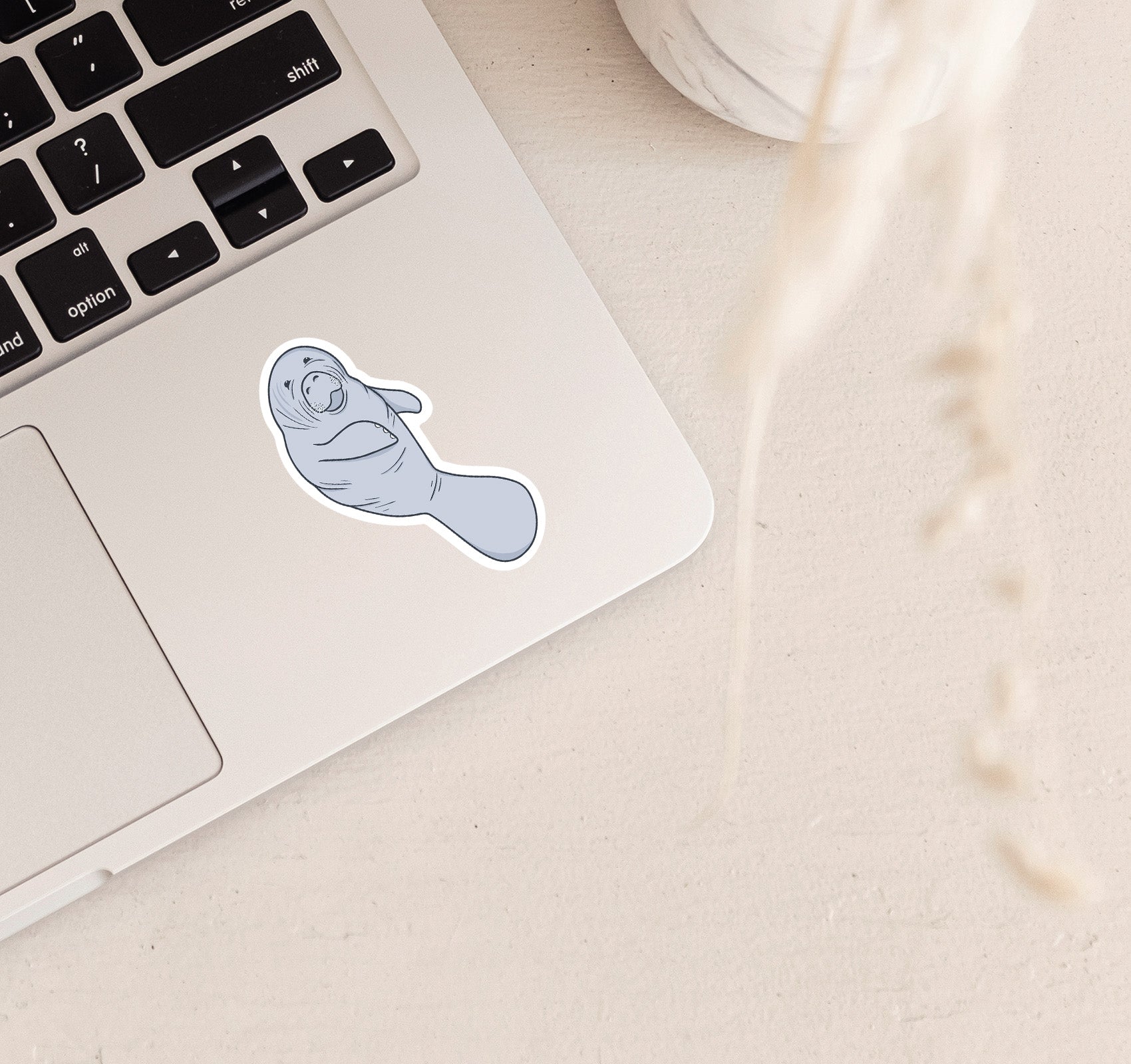 Sticker of manatee illustration on a laptop