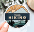 Mountain sticker with a trail, pine trees, and a sunset with the phrase "probably hiking"