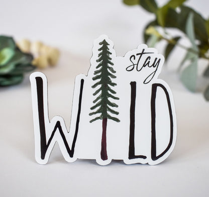 A stay wild magnet with a pine tree design