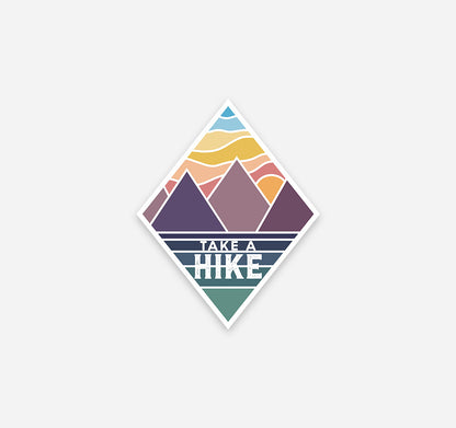 Take a hike sticker with mountains at sunset