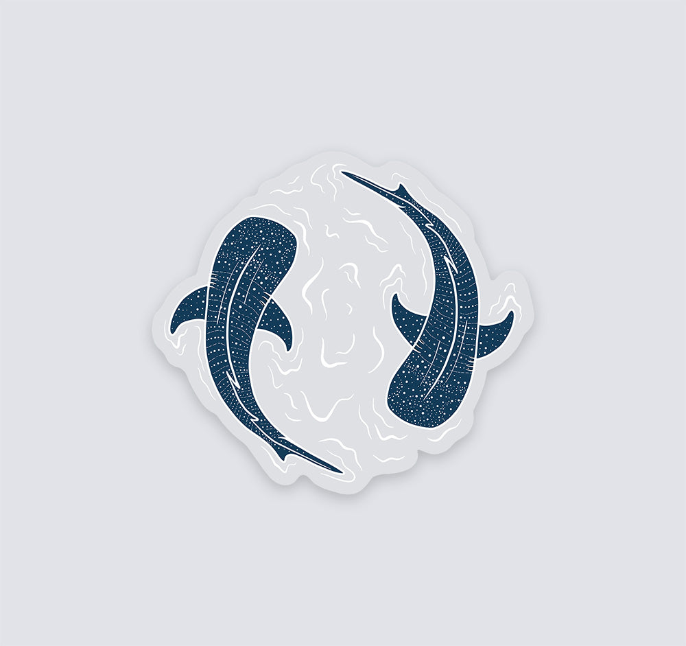 A die-cut vinyl sticker featuring two dark whale sharks swimming in a circular white wave design, shown on a solid light gray background.