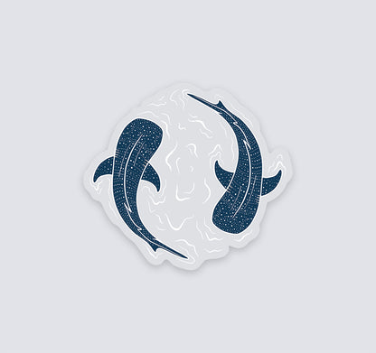 A die-cut vinyl sticker featuring two dark whale sharks swimming in a circular white wave design, shown on a solid light gray background.